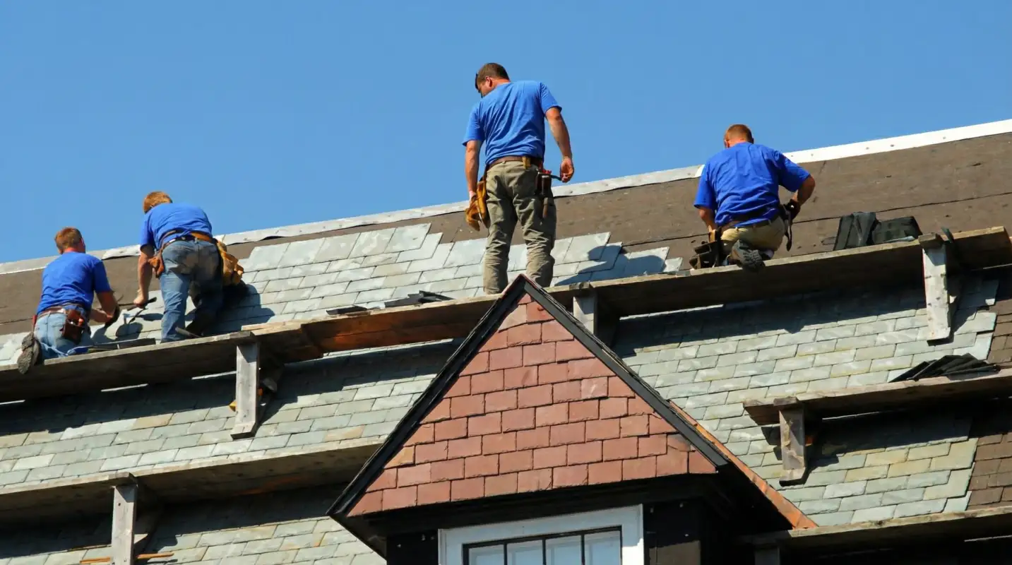 Roof replacement in progress with a team of professional contractors installing new shingles on a residential home in Albany, NY