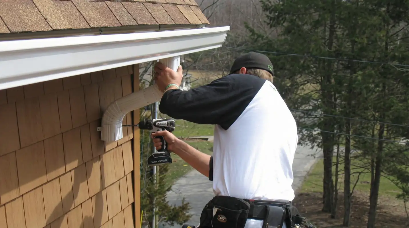 Professional contractor installing tan vinyl siding panels on a residential home exterior in Albany, NY